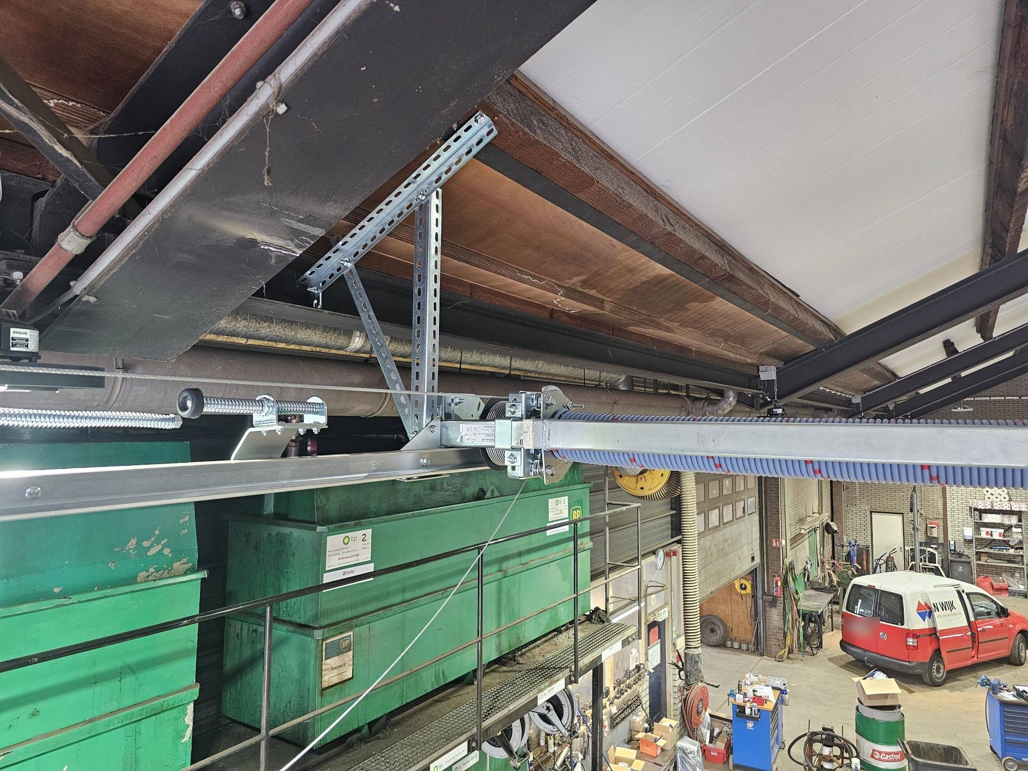 Detail van rails, kabeltrommel en veerpakket van een sectionaaldeur
