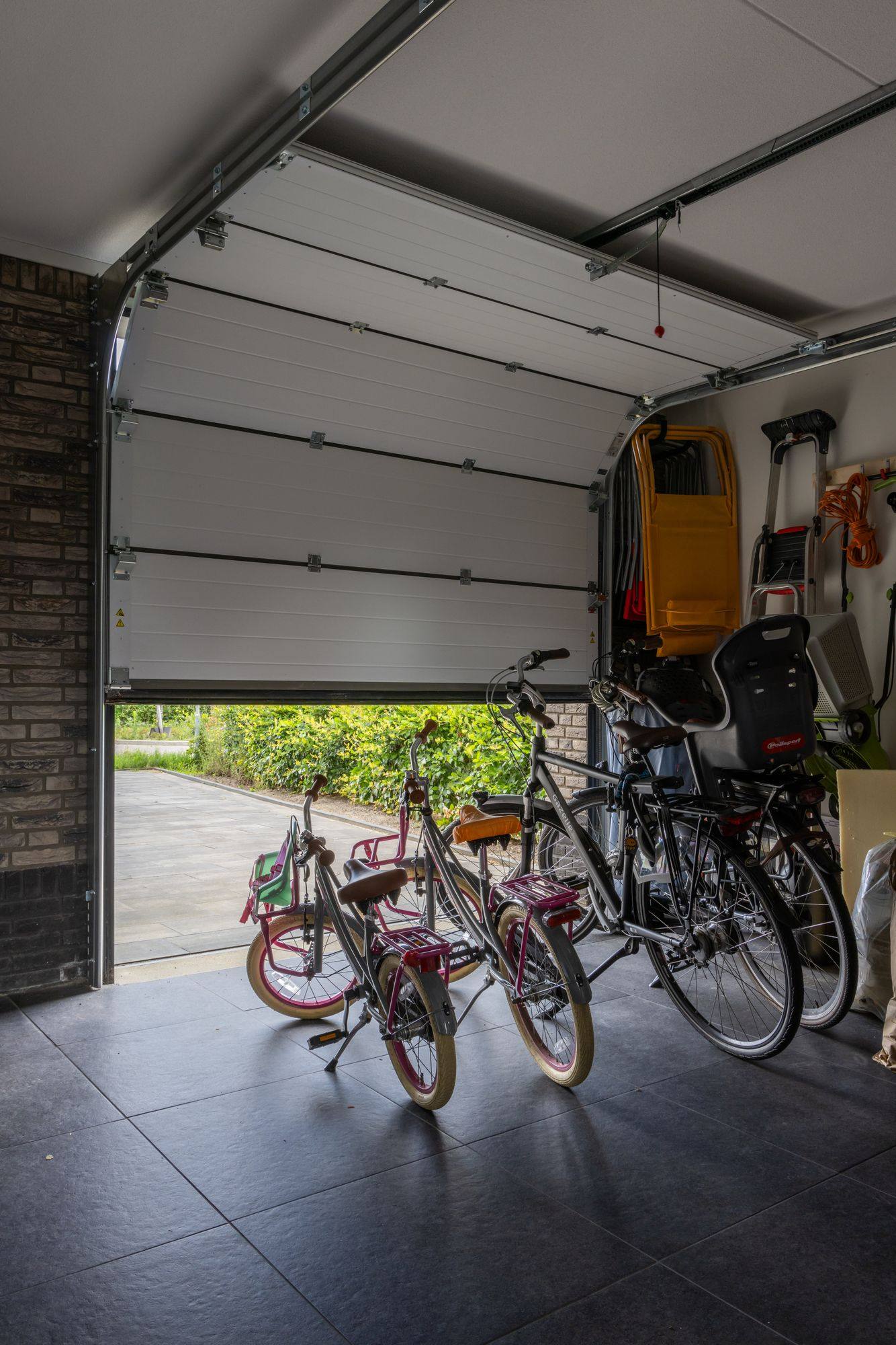 Binnenzijde van een geopende sectionaal garagedeur met geleiderails en fietsen